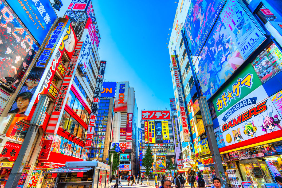 People strolling past vibrant buildings in Tokyo