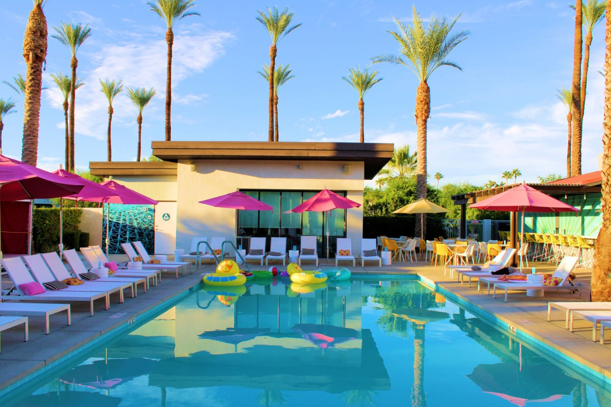 Palm trees and lounge chairs at resort pool in Palm Springs, CA